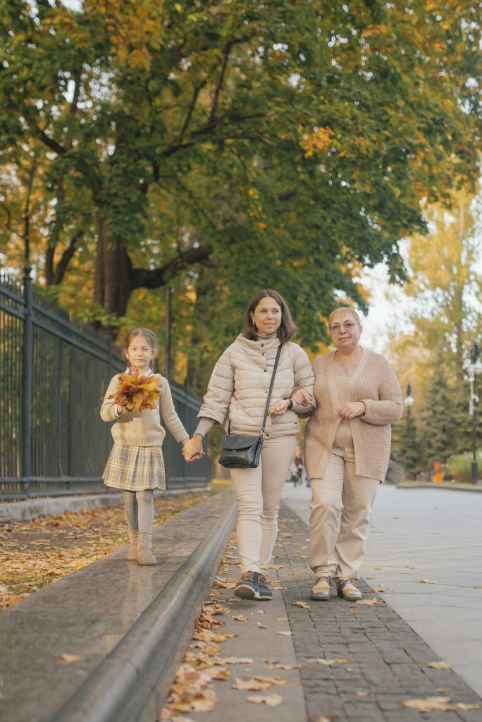 Family - three generations. A walk in the park in autumn. Grandmother, mother and daughter.